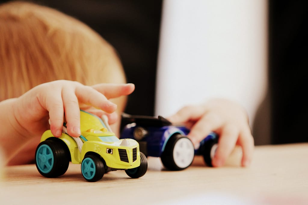 Toddler playing with toy cars