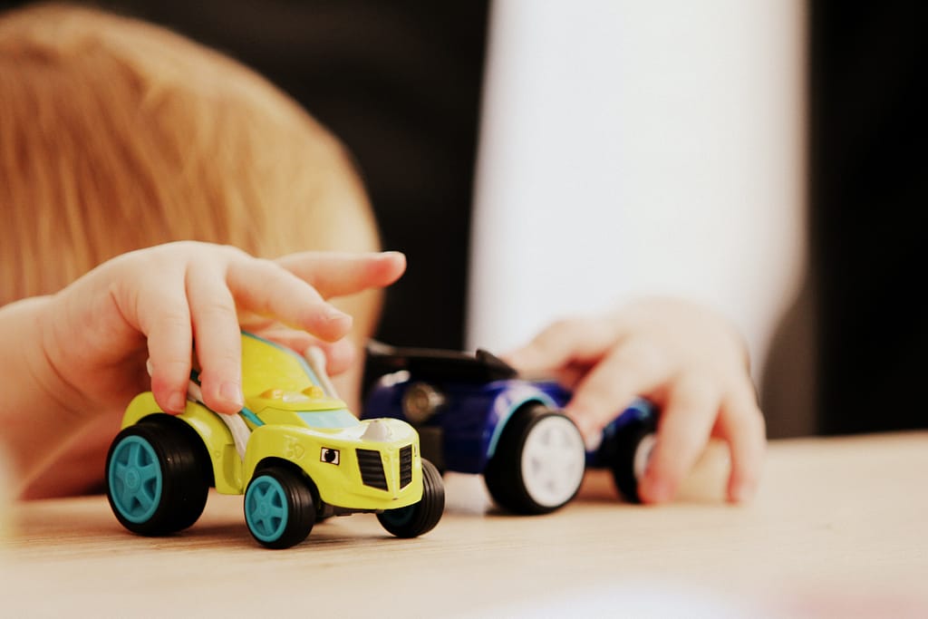Toddler playing with toy cars
