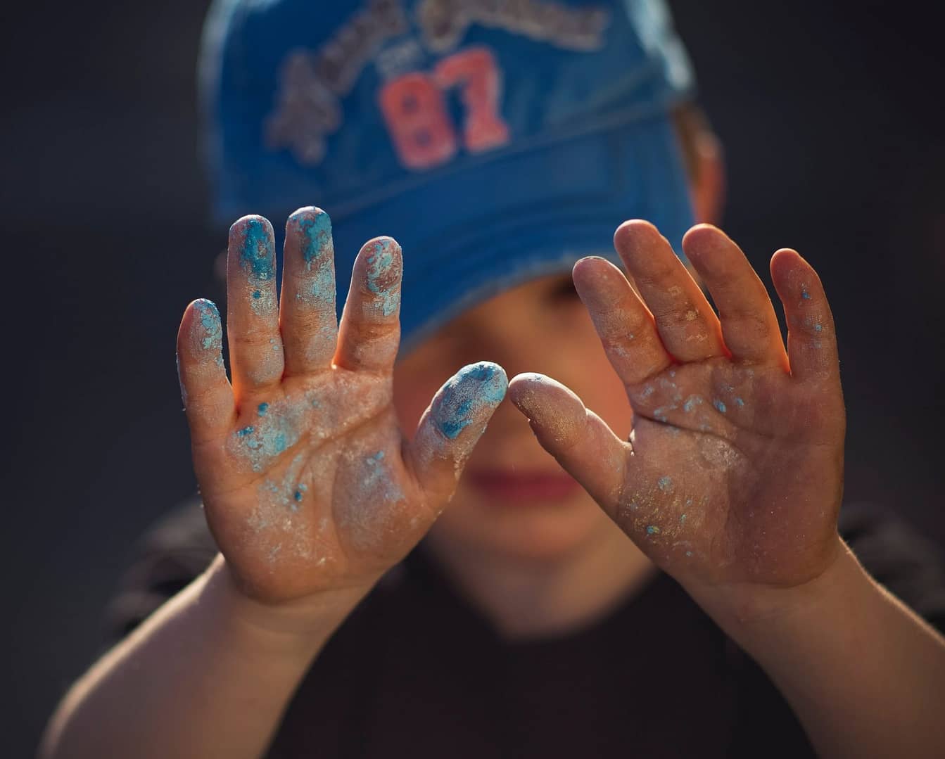 Childs hand covered in blue paint/chalk