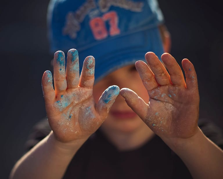 Childs hand covered in blue paint/chalk